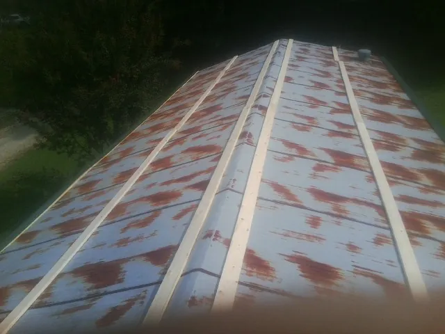 Rusted metal roof panels with new wood purlins before replacement — Storm Damage Roof Repair in Wilton by Roofing Brothers