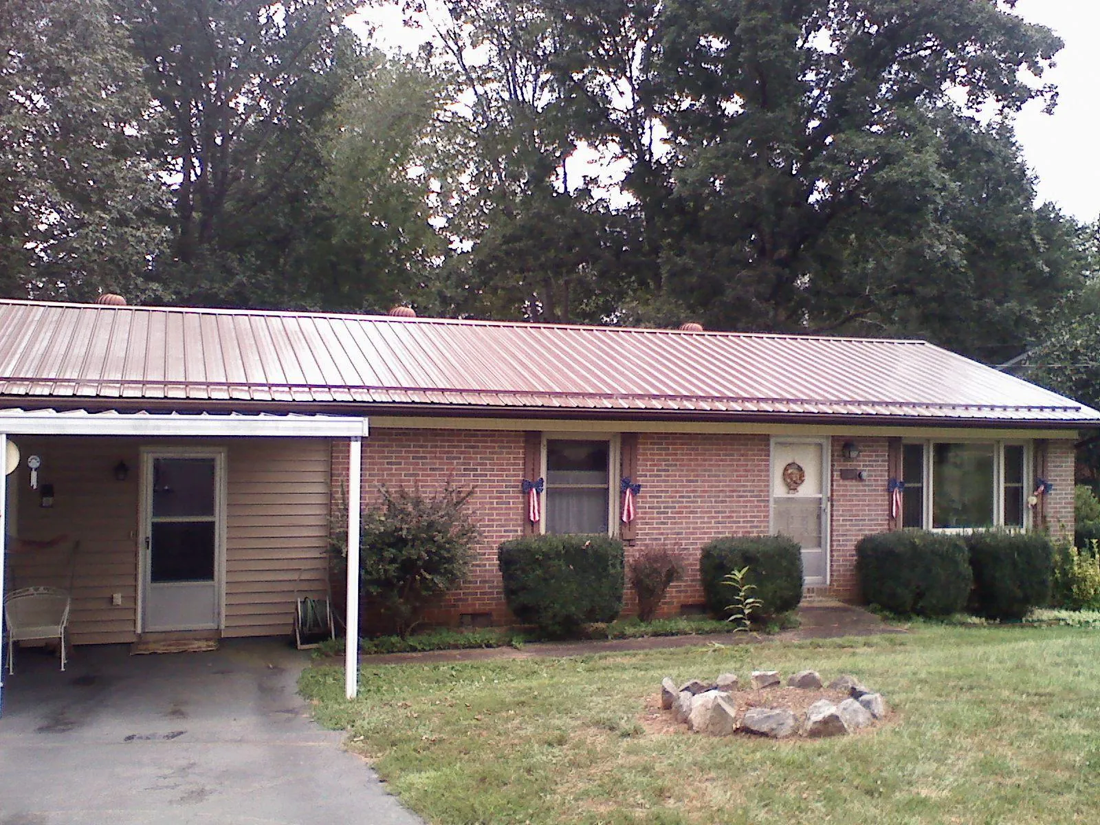 Bronze metal roof and carport on a brick ranch home — Roof Repair work by our crew in Wilton